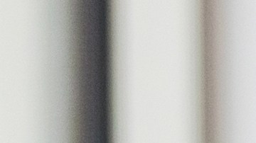 Mid adult female bank employee discusses a mobile banking app's features with a mature female client.