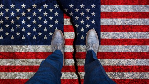 Business,Man,Stands,On,Cracked,Flag,Of,Usa.,Political,Concept