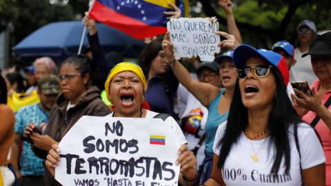 Una mujer sostiene un cartel con un mensaje en español que dice: "No somos terroristas" en Caracas, Venezuela.