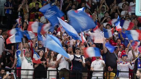 Aficionados franceses ondean banderas en los Juegos Olímpicos 2024.