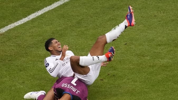 El portero del Atalanta, Juan Musso, a la izquierda, realiza una atajada frente a Jude Bellingham del Real Madrid durante el partido de fútbol de la final de la Supercopa de la UEFA entre el Real Madrid y el Atalanta en el estadio Narodowy en Varsovia, Polonia, el miércoles 14 de agosto de 2024. (AP Photo/Darko Vojinovic)