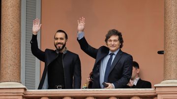 El presidente argentino, Javier Milei (d) acompañado del presidente de El Salvador Nayib Bukele, saludan a seguidores en La Casa Rosada este lunes en Buenos Aires (Argentina).