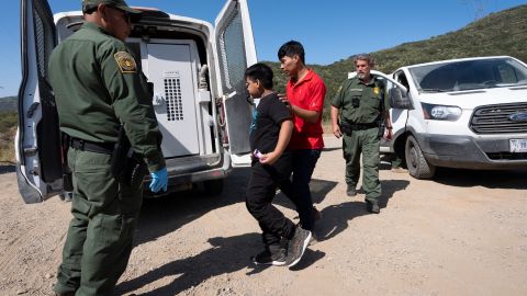 Agentes de la Patrulla Fronteriza conducen a un grupo de migrantes que buscan asilo hacia una camioneta para ser transportados y procesados. Foto referencial.