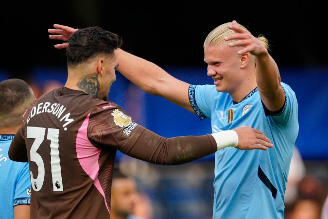 Ederson (L) y Haaland se abrazan posterior a un juego del Manchester City en Premier League.