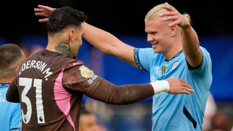 Ederson (L) y Haaland se abrazan posterior a un juego del Manchester City en Premier League.