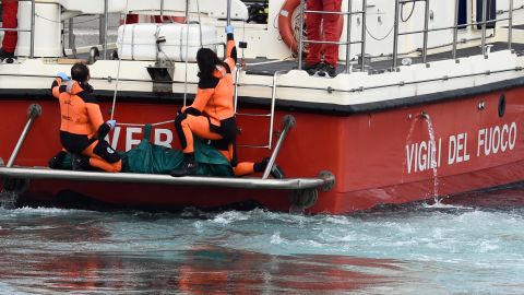 Los buzos de los bomberos italianos sacan a tierra en una bolsa verde el cuerpo de una de las víctimas del barco de bandera británica Bayesian.