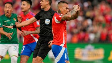 Eduardo Vargas (C) celebra su gol ante Bolivia a pesar de ser increpado por los rivales.