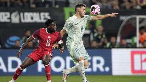 El canadiense Alphonso Davies disputa un balón con Santiago Gimenez.