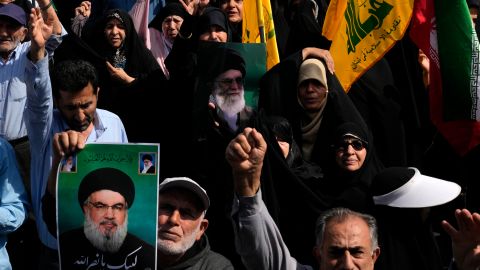 Los fieles iraníes corean consignas mientras sostienen carteles del líder supremo, el ayatolá Ali Khamenei.