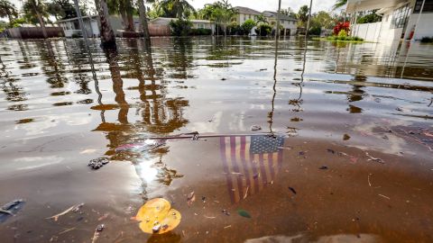 Una bandera estadounidense ondea en las aguas de las inundaciones tras el paso del huracán Helene en el vecindario de Shore Acres, Florida.