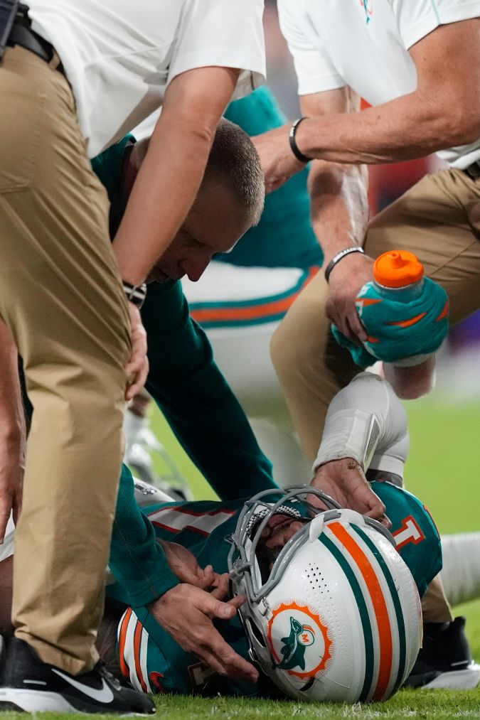 El mariscal de campo de los Miami Dolphins, Tua Tagovailoa (1), recibe asistencia en el campo después de sufrir una conmoción cerebral durante la segunda mitad de un partido de fútbol americano de la NFL contra los Buffalo Bills, el jueves 12 de septiembre de 2024, en Miami Gardens, Florida. (Foto AP/Rebecca Blackwell.)