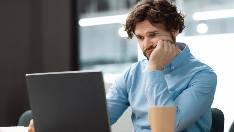 Portrait,Of,Sad,Bored,Business,Man,Sitting,At,Desk,Using