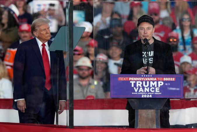 Trump escucha a Musk hablar durante un mitin de campaña en el Butler Farm Show, Pensilvania.