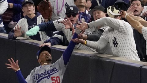 Fanáticos de los Yankees interfieren con la jugada del jardinero de Los Angeles Dodgers Mookie Betts.