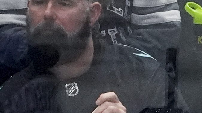 Entrenadora asistente de los Seattle Kraken, Jessica Campbell, vestida de blanco, observa desde el banquillo durante el primer período de un partido de hockey de la NHL contra los St. Louis Blues, el martes 8 de octubre de 2024, en Seattle.