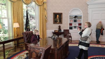 Fotografía del 17 de octubre de 2024 de personas tomando fotos en el Despacho Oval del museo interactivo 'The People's House' (La Casa del Pueblo), una réplica de la Casa Blanca, en Washington (EE.UU.).