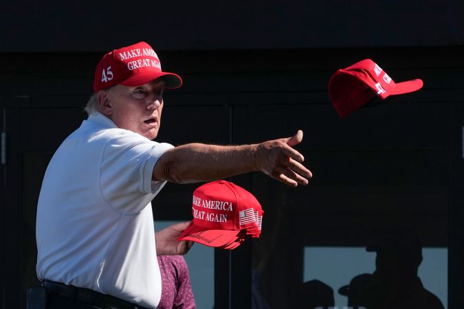 Trump lanza gorras autografiadas a la multitud durante la ronda final del torneo de golf Bedminster Invitational LIV en Bedminster, Nueva Jersey.