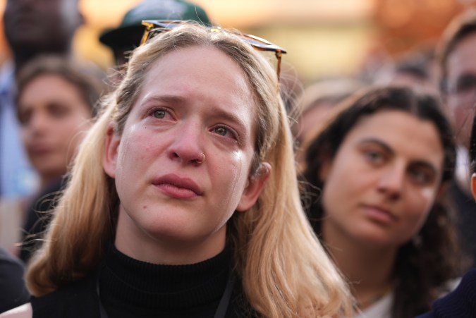 Un simpatizante llora mientras la vicepresidenta Kamala Harris pronuncia un discurso de concesión después de las elecciones presidenciales de 2024.