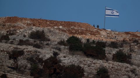 Soldados israelíes posan junto a su bandera nacional en una zona del sur del Líbano, vista desde el norte de Israel.