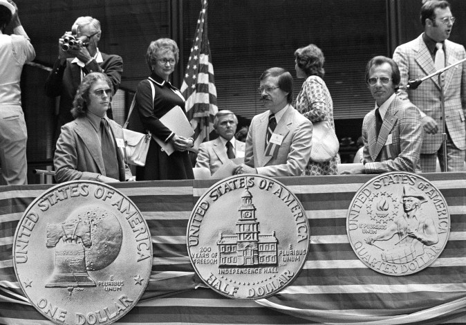 Los diseñadores de las monedas de dólar, medio dólar y cuarto de dólar del bicentenario posan detrás de réplicas ampliadas de su trabajo en las ceremonias inaugurales en Chicago el 18 de agosto de 1975.