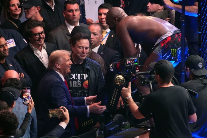 El presidente electo Donald Trump le entrega el cinturón a Jon Jones después de que este venciera a Stipe Miocic en el UFC 309 en el Madison Square Garden, la madrugada del domingo 17 de noviembre de 2024 en Nueva York. (Foto AP/Evan Vucci).