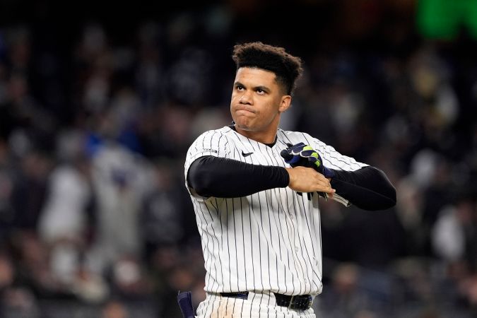 Juan Soto, de los Yankees de Nueva York, se quita los guantes de bateo después de hacer un roletazo contra los Yankees de Nueva York para cerrar la tercera entrada del tercer juego de la Serie Mundial de béisbol, el lunes 28 de octubre de 2024, en Nueva York. (Foto AP/Godofredo A. Vásquez).