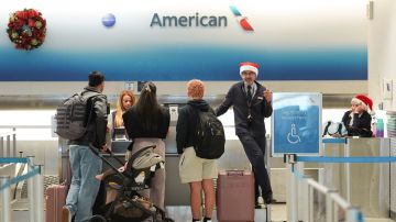 Los empleados de American Airlines, algunos con gorros de Papá Noel, registran a los pasajeros en la terminal de American en el Aeropuerto Internacional de Miami, en Nochebuena, el martes 24 de diciembre de 2024, en Miami.