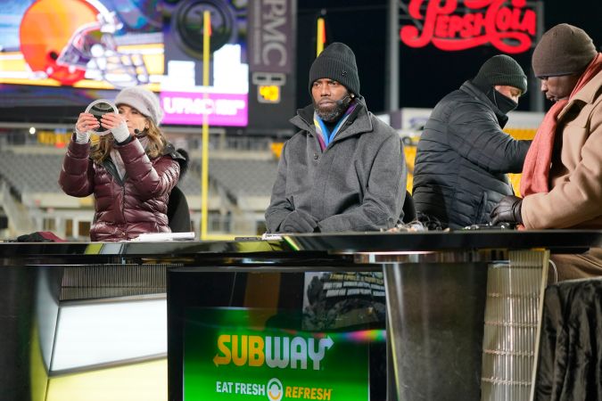 Los presentadores Suzy Kolber (izquierda), Randy Moss (centro) y Sean McFarland se preparan en el plató antes de un partido de fútbol americano de la NFL entre los Pittsburgh Steelers y los Cleveland Browns, el lunes 3 de enero de 2022, en Pittsburgh. (Foto AP/Gene J. Puskar)