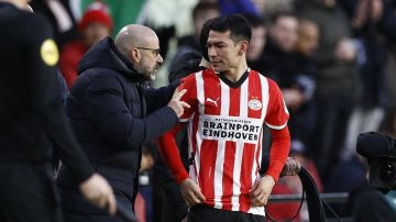 El DT Peter Bosz habla con Hirving "Chucky" Lozano antes de su entrada en el encuentro entre el PSV Eindhoven y el Feyenoord.