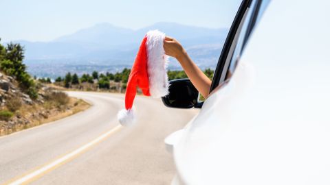 Woman,Driving,A,Car,Holding,Santa,Claus,Hat,From,The