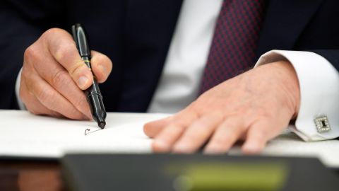 El presidente Donald Trump firma órdenes ejecutivas en la Oficina Oval de la Casa Blanca.