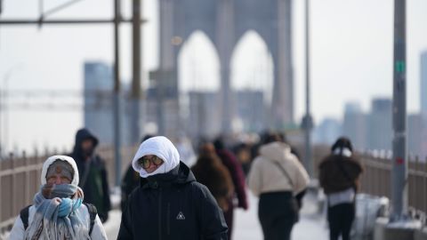 Peatones abrigados cruzan el puente de Brooklyn en Nueva York.