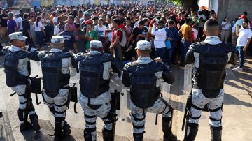 Personal de la Guardia Nacional (GN) bloquea el avance de migrantes a las oficinas de migración este lunes, en el municipio de Tapachula en Chiapas (México).