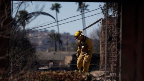 Bomberos y equipos de búsqueda y rescate inspeccionan el lugar de una casa incendiada en Altadena, California, EE.UU., el 13 de enero de 2025.