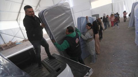 Trabajadores descargan colchones para la llegada de migrantes deportados este miércoles, en Ciudad Juárez, Chihuahua (México).