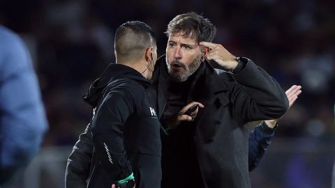 Gustavo Lema (R) discute con el cuarto árbitro durante un duelo ante América.