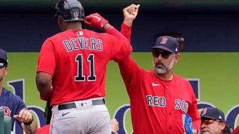 Alex Cora (R) felicita a Rafael Devers (L) tras jonrón de tres carreras frente a Atlanta Braves.