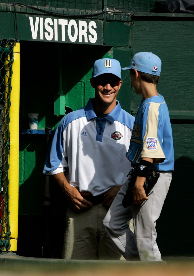 Clay Bellinger, de Chandler, Arizona, a la izquierda, sonríe a su hijo y al jugador de Arizona Cody Bellinger cuando entran al dugout en la tercera entrada contra Salisbury, Maryland, durante la serie de grupos de la Serie Mundial de Pequeñas Ligas de 2007 en South Williamsport, Pensilvania, el sábado 18 de agosto de 2007. (Foto AP/Carolyn Kaster, Archivo)