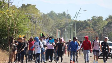 Migrantes caminan después de regresar de la Comisión Mexicana de Ayuda a Personas Refugiadas (Comar), en espera de resolver su situación migratoria este jueves en la ciudad de Tapachula en el estado de Chiapas (México).