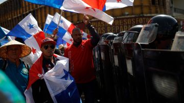 Un grupo de personas protestan frente a unidades antidisturbios por la visita del Secretario de Estado de Estados Unidos, Marco Rubio, este domingo en Ciudad de Panamá (Panamá).