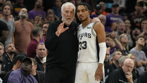 Gregg Popovich conversa con Tre Jones durante un juego entre los San Antonio Spurs y los Phoenix Suns en 2023.