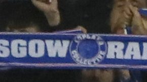 Hinchas de Rangers FC alzan sus bufandas para apoyar a su equipo.
