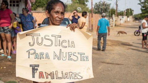 Una mujer sostiene un cartel durante una protesta en el barrio Los Pescadores este lunes, en Maracaibo (Venezuela).