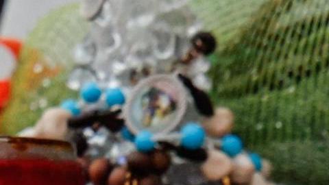 Una vela con la imagen del papa Francisco (centro) se coloca bajo la estatua de Juan Pablo II en el exterior del Hospital Agostino Gemelli, donde el papa Francisco permanece ingresado, en Roma, Italia, el 12 de marzo de 2025.