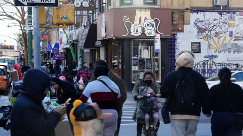 Carteles en inglés y español identifican negocios en Brooklyn, Nueva York.