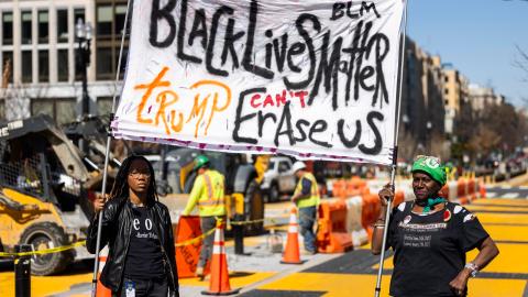 Manifestantes sostienen un cartel mientras equipos del gobierno local comienzan la reconstrucción de la Plaza Black Lives Matter (BLM) frente a la Casa Blanca en Washington, DC, EE.UU., el 10 de marzo de 2025.