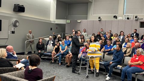 El senador de Arizona Mark Kelly conversa con una mujer, durante una asamblea pública organizada por la Oficina del Senador.