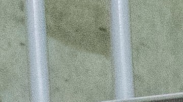 El ministro de Justicia y Seguridad Pública, Héctor Villatoro (izquierda), acompaña a la secretaria de Seguridad Nacional, Kristi Noem (centro), mientras observan a los presos en una celda durante un recorrido por el Centro de Reclusión de Terroristas en Tecoluca, El Salvador, el miércoles 26 de marzo de 2025.