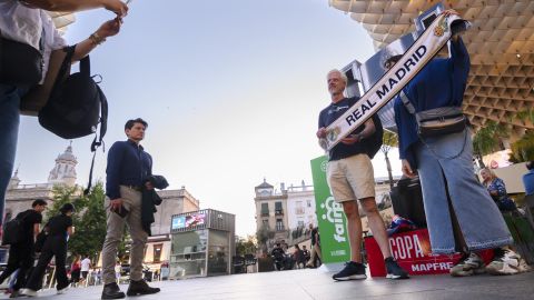 Un grupo de personas con una bufanda del Real Madrid este viernes, en la plaza de La Encarnación de Sevilla la víspera del encuentro de la final de la Copa del Rey que enfrenta al Real Madrid y al FC Barcelona.