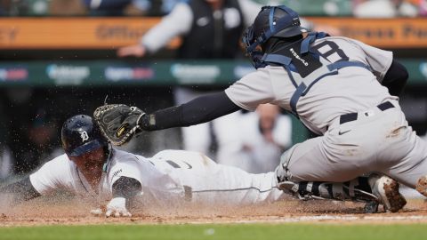 Jake Rogers se barre para lograr la carrera ante el catcher de los Yankees Austin Wells.
